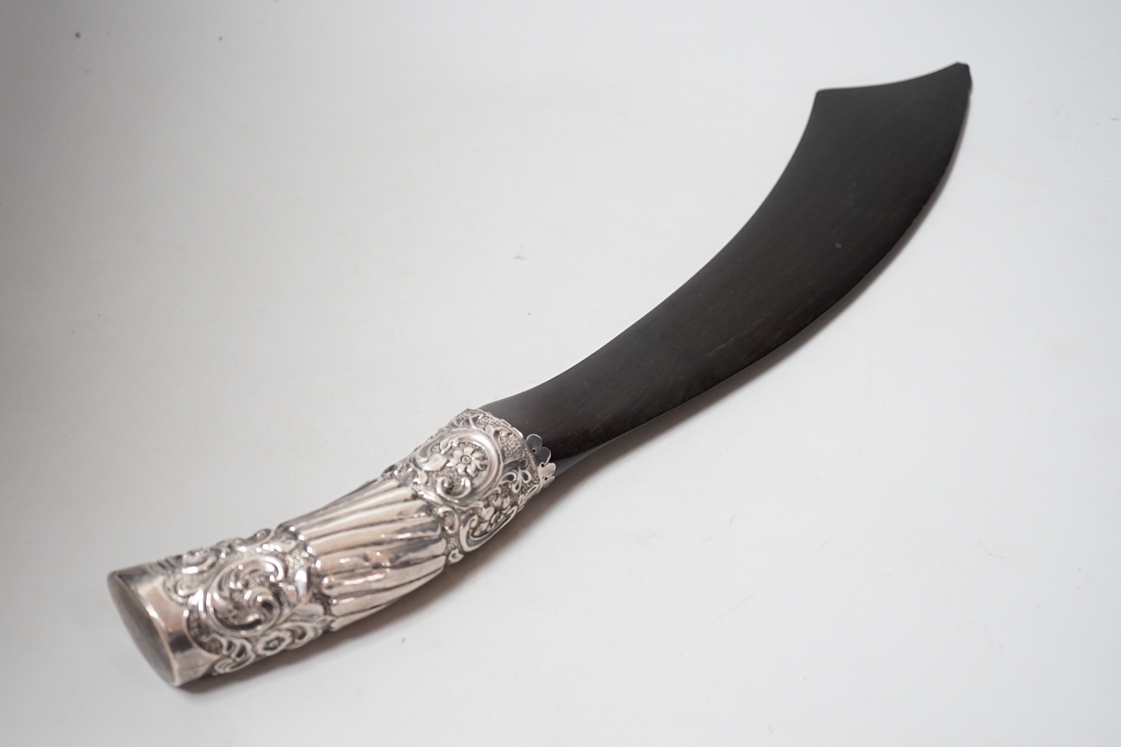 A Victorian repoouse silver handled ebony 'scimitar' page turner, Rosenthal, Jacob & Co, London, 1889, 48.9cm.